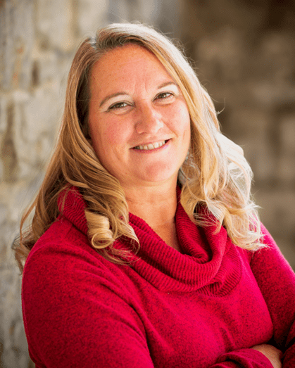 A woman in red shirt smiling for the camera.